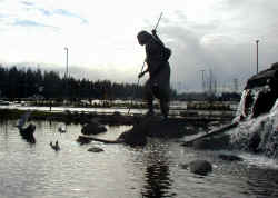 Giant Indian spearing a salmon in front of the Tulalip Casino.