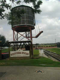 The Tarantula Train's water tower next to the Cowtown Cattlepen Maze across from Stockyards Station in the Fort Worth Stockyards.