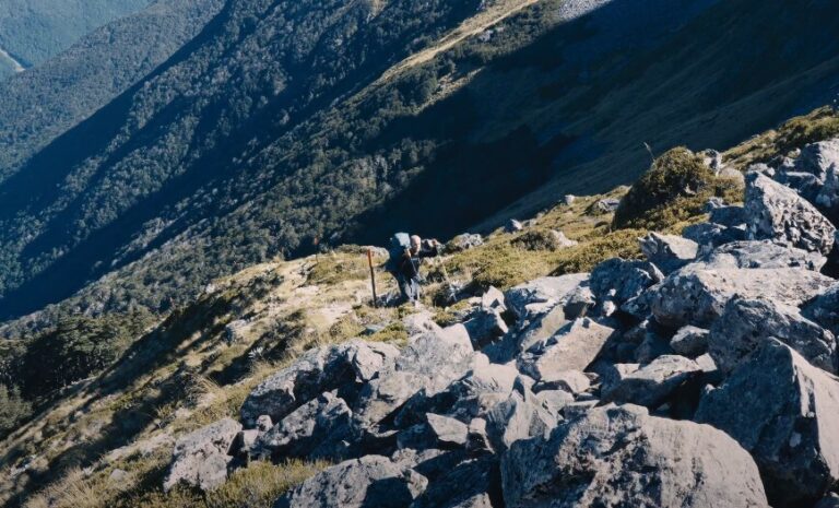 The rugged landscape reveals a trail winding through a field of boulders