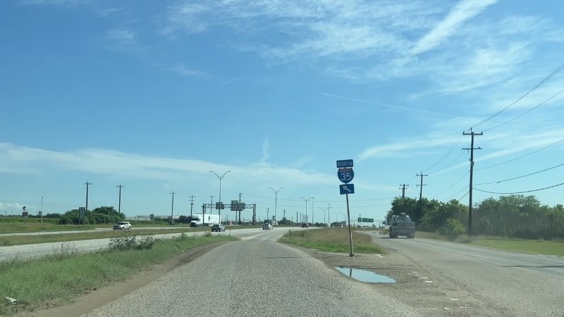 A view of a section of I-35 with a road sign directing traffic north