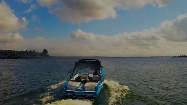 Motorboat cruising across Lake Austin with calm water and city shoreline in the background